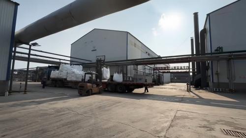 在工廠廠區中，工作人員正在進行聚丙烯酰胺產(chan) 品的裝車工作，細節展示了裝車的專(zhuan) 業(ye) 操作。